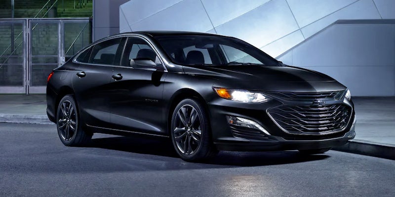 Black Chevrolet Malibu sedan parked on a city street at night