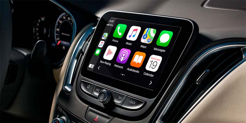 Close-up of the Chevrolet Malibu infotainment touchscreen displaying smartphone integration apps including Phone, Music, Maps