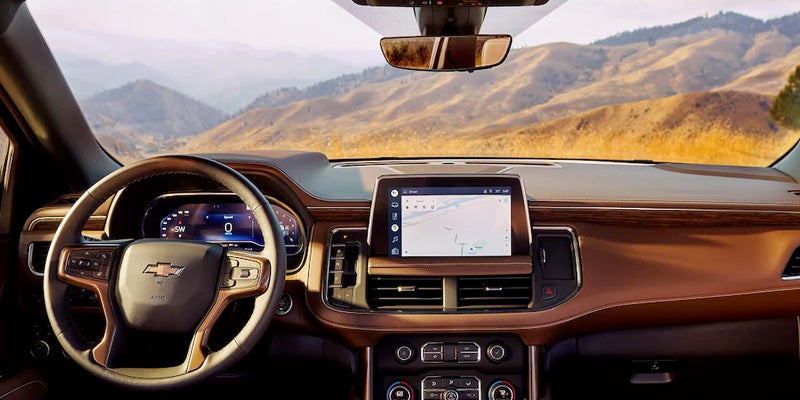 Driver-focused view of a vehicle interior showing the steering wheel, digital instrument cluster