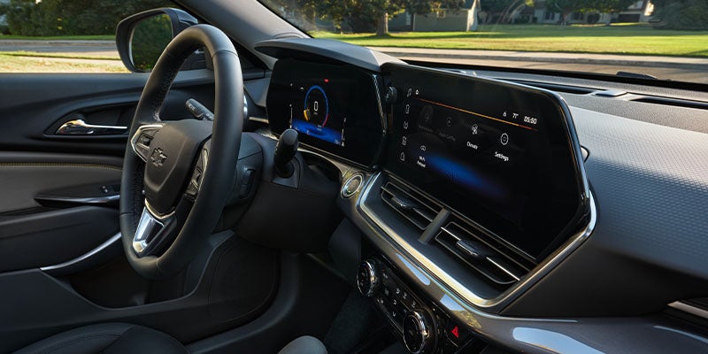 Interior view of a Chevrolet SUV showing the steering wheel, digital instrument cluster, widescreen infotainment display,